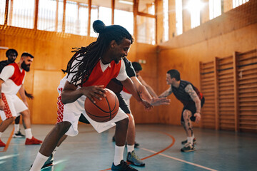 Arabic man basketball player dribbling the ball during game with his teammates