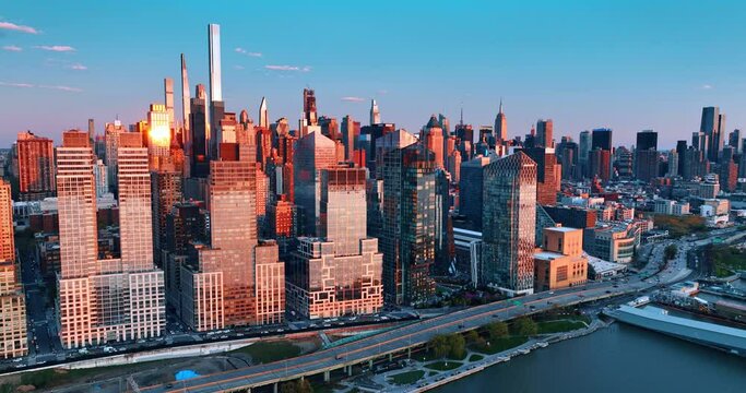 Manhattan scenery in pink light of sunset. Drone footage above the East River in New York, USA.