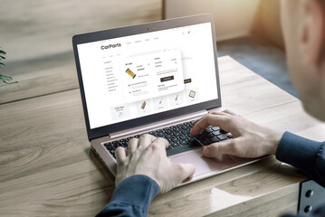 Man purchases car parts online at the Car Parts website. Concept of buying auto parts conveniently through e-commerce