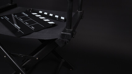 Director chair and Clapper board on black background.