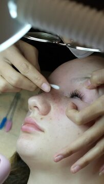 Lashmaker Applies Serum on Eyelashes of Client For Eyelash Lamination Treatment Procedure In Beauty Salon. Curling, Staining, Extension Procedures For Lashes. Horizontal. Step By Step. Slow Motion