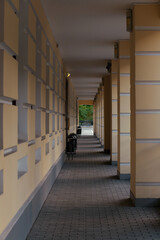 Building architecture passage with columns, Straight long gallery corridor. Perspective view of street sideway passage in modern building.
