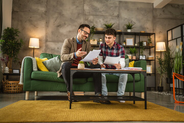 Obraz premium Adult professor mentor and young student hold papers and renew lesson