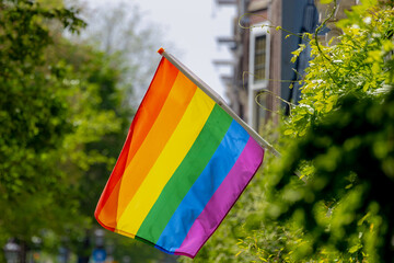 Celebration of pride month in Amsterdam, Colourful rainbow flag hanging on the window, The symbol...