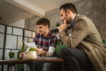 Adult professor mentor and young student read together lesson at home