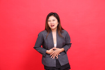 indonesia office woman's expression in pain, stomach ache, looking at the camera wearing a gray...