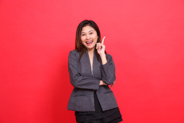 Asian office woman's gesture to the camera gets the idea of arms crossed, wearing a gray jacket and...