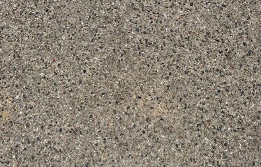 An aerial view captures a sandy and gravelly roadway, showcasing textures like grains, pebbles, and tracks, embodying ruggedness and connectivity.