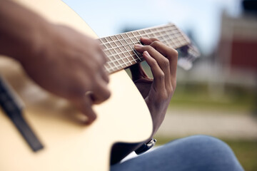 Man, guitar and hands in garden for music, sound and performance in nature. Gen z male person,...