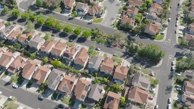 Aerial drone shot of California neighborhood, slow reveal of homes from above tilt up landscape, suburbs - 4K
