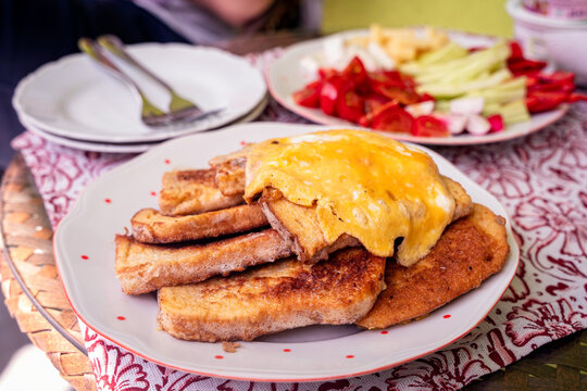 Egg coated fried bread, salty French toast with vegetables, outdoors brunch