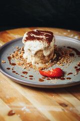 Delectable Tiramisu Served on a Ceramic Plate Garnished With Strawberry and Cocoa