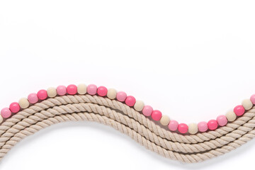 wavy thick textured rope and smooth wooden bead border in shades of off white and pink on a white...