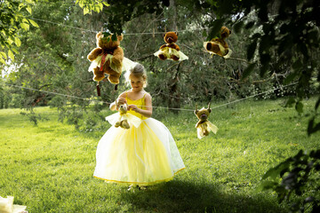 Girl in yellow dress with plush toys on a clothesline.