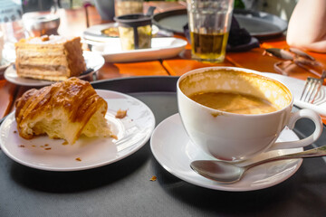 Breakfast view a bunch of croissant and a cup of coffee with cafe vibe background.