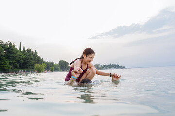 smiling girl sitting on the neck of the father standing in the water preparing for a jump having fun