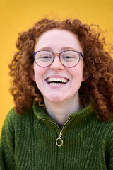 Vertical. Portrait of young redhead girl with glasses curly hair looking at camera with nice...