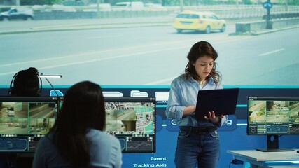 Young manager analyzing traffic surveillance data with her employees team, using the CCTV security...
