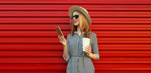Summer portrait stylish happy young woman with mobile phone looking at device holding cup of coffee