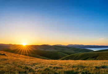 Panorama of sunrise, sunset, over hills, pasture, meadows, grass and ocean, lake