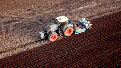 Traktor mit Sämaschine bei der Aussaat von Mais auf einem Acker auf, Landwirtschaft, Drillsaat,...