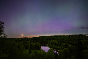 Aurora Borealis northen lights above Gauja river in Sigulda, Latvia  at May.