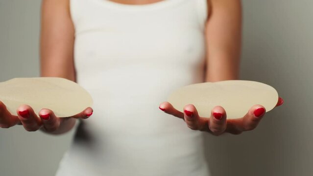 Medical Decision: Woman Holds Removed Breast Implants After Surgery