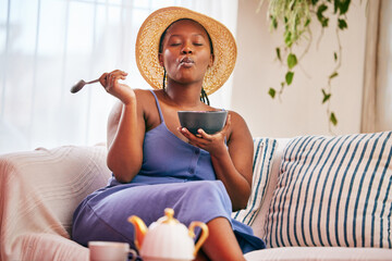 Black woman, food and couch in house with eating breakfast for morning meal, healthy diet and...