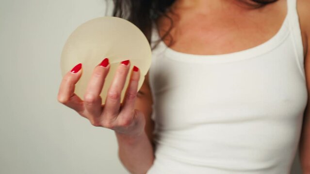 Bravery Revealed: Woman Displays Removed Breast Implants After Surgery