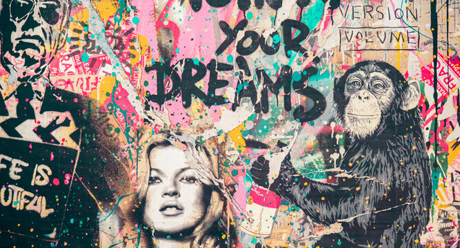 Colorful grunge urban street of a graffiti wall art in a vintage or retro style with ripped off collage prints showing a woman and a monkey in Wynwood, Miami, Florida.