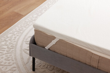 White memory foam mattress topper on grey bed indoors