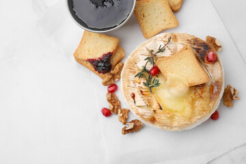 Flat lay composition with tasty baked camembert on white table. Space for text