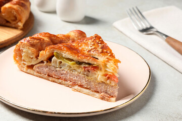 Piece of tasty homemade pie with filling on light grey table