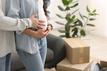 Pregnant woman and her husband in their new apartment, closeup. Space for text