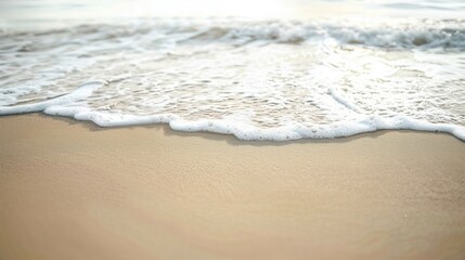 beige sand and water, gentle waves in the background, muted colors