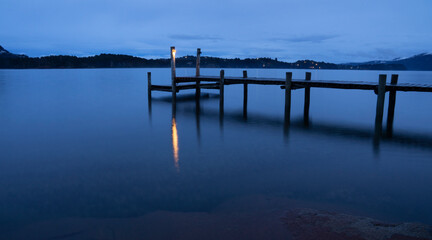 Magical view of the wooden dock in the placid lake at nightfall. Long exposure shot of the the...
