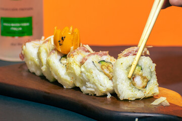 Maki rolls about to be eaten with chopsticks, a delicious meal.