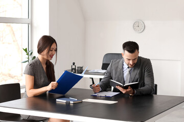 Human resources manager interviewing applicant at table in office