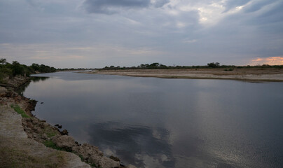 Panorama view of the calm river and shore under a magical sunset sky