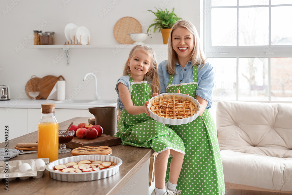 Poster Cute little girl and her mother with prepared apple pie in kitchen