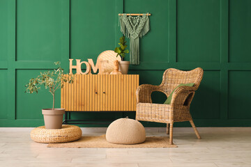 Interior of stylish living room with wicker armchair, commode and poufs