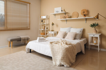 Interior of bedroom with clean towels on bed