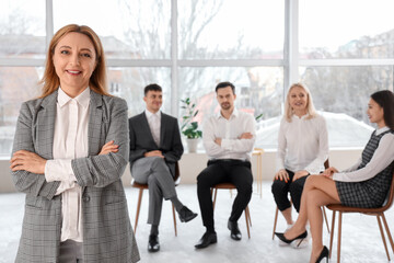 Mature business woman smiling at group therapy session