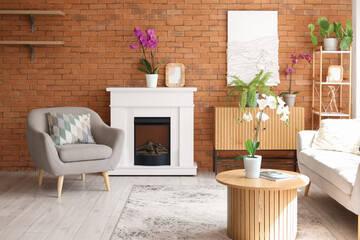 Fototapeta premium Interior of living room with fireplace, armchair and orchid flowers