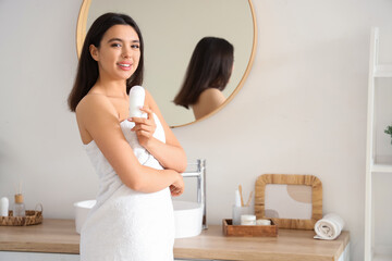 Young woman with deodorant in bathroom