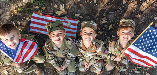 Memorial Day cheer: Four children dressed in soldier uniforms holding flags, viewed from above.