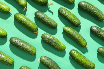 Fresh green cucumbers on color background