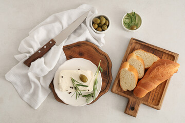 Plate with tasty feta cheese, olive, rosemary and peppercorn on white background