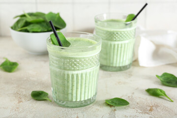 Glasses of fresh spinach smoothie on white table