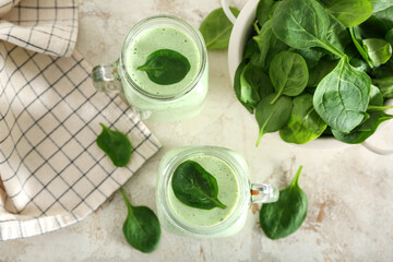 Mason jars of fresh spinach smoothie on white table